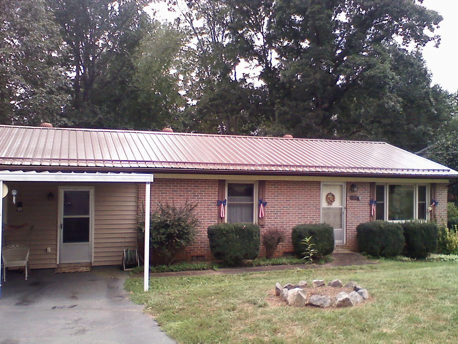 Bronze metal roof and carport on a brick ranch home — Roof Repair work by our crew in Soldier